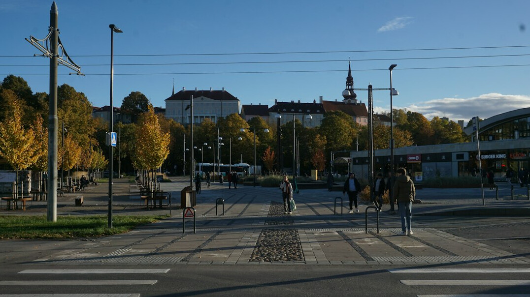 Distant anonymous silhouettes of people crossing an urban square